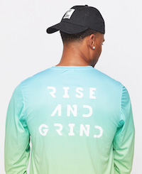the backside of a long-sleeved exercise tee in a blue and green gradient color with the words "Rise and Grind"